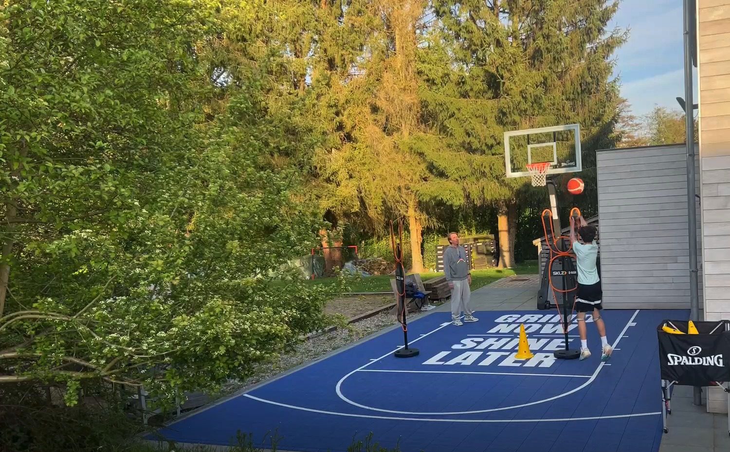 Tom Blight sur le terrain à côté d'un joueur au tir, Grind Now Basketball Lab à Bousval
