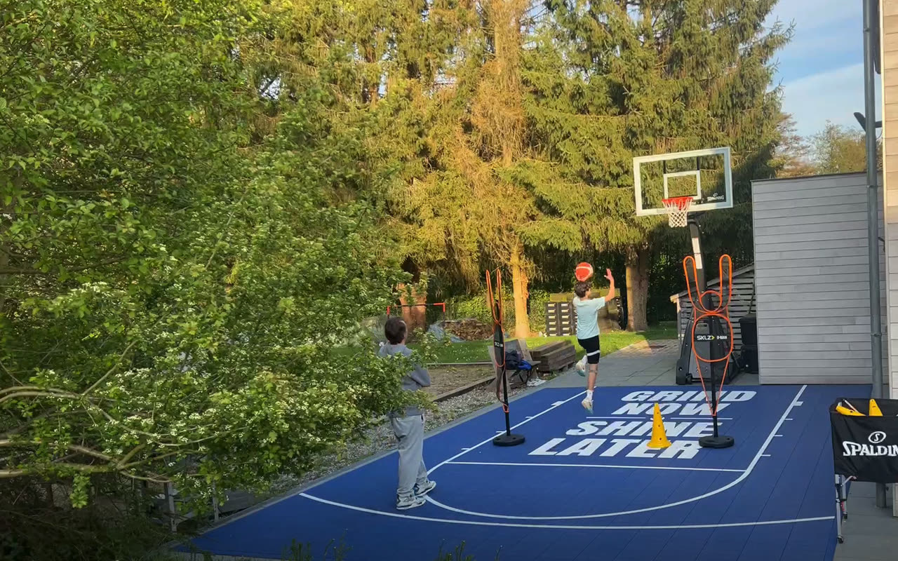 Joueur au tir à côté d'un mannequin de défense, Tom Blight au bord du terrain du Grind Now Basketball Lab à Bousval